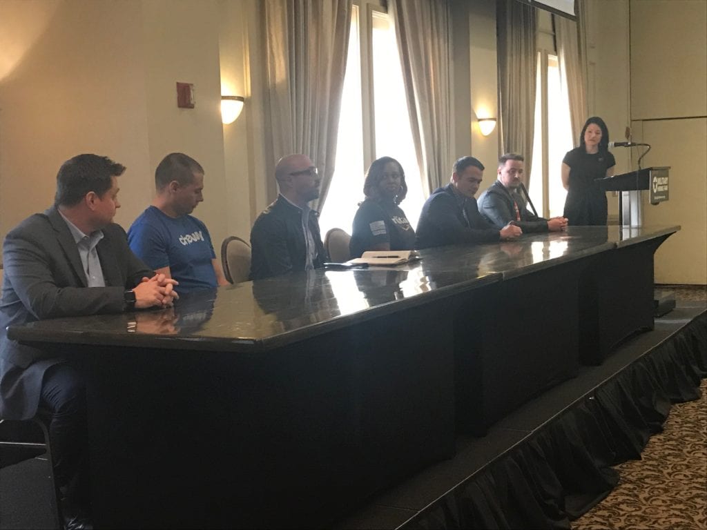 A panel of speakers onstage at a military hiring fair.