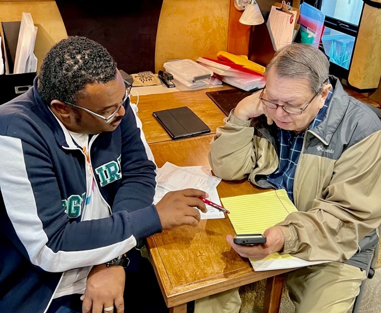 Comcast employee teaching a senior citizen how to use his phone's services