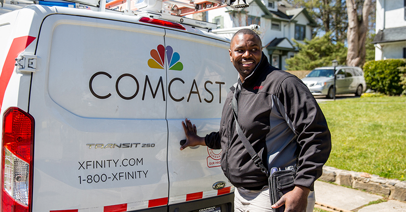 man standing next to comcast truck