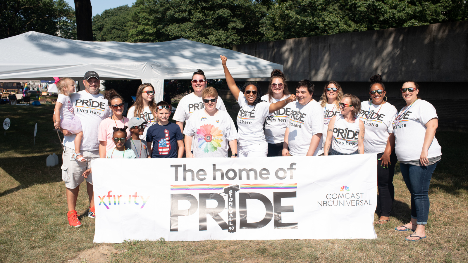 Comcast volunteers hold up a banner commemorating Pride month.