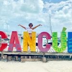 Dana Brooks behind a Cancun sign