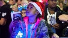 little girl wearing a Santa hat looking up