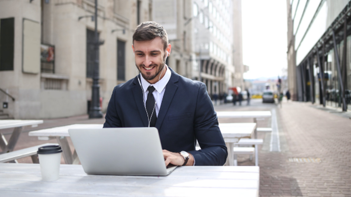 man typing on laptop outdoors