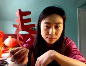 Woman holding cut paper Chinese symbol for "Spring"