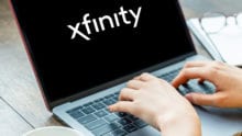 Person typing on laptop with Xfinity logo on screen
