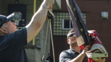 Comcast employees lowering American flag