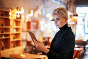 Woman looking at tablet computer inside her business
