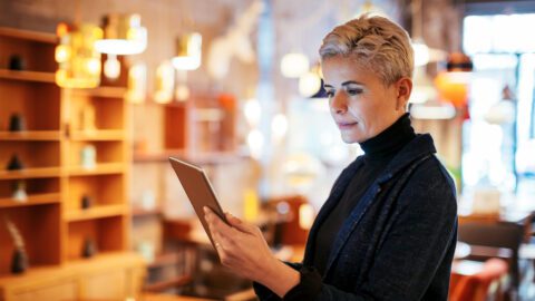 Woman looking at tablet computer inside her business