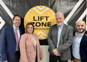 Four people in front of Lift Zone banner