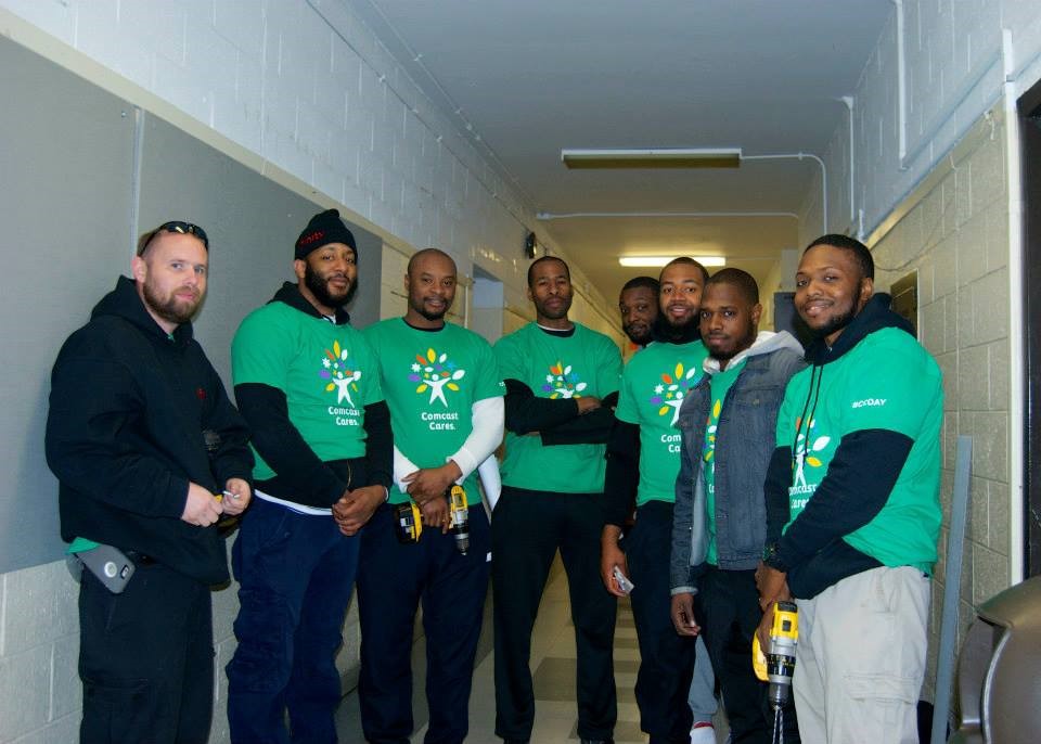 This crew of Comcast engineers led by Chris Powell installed fabric-covered panels along the first-floor hallway wall, repainted that wall, and then kept working to repaint the doors in the courtyard.