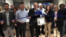 Comcast Beltway region employees in new Xfinity store standing in front of a ribbon