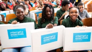 Students receive Internet Essentials laptops at an event in Boston.