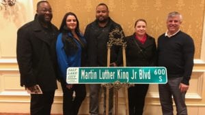 Members of the Comcast Black Employee Network stand in front of a Martin Luther King Jr. street sign.