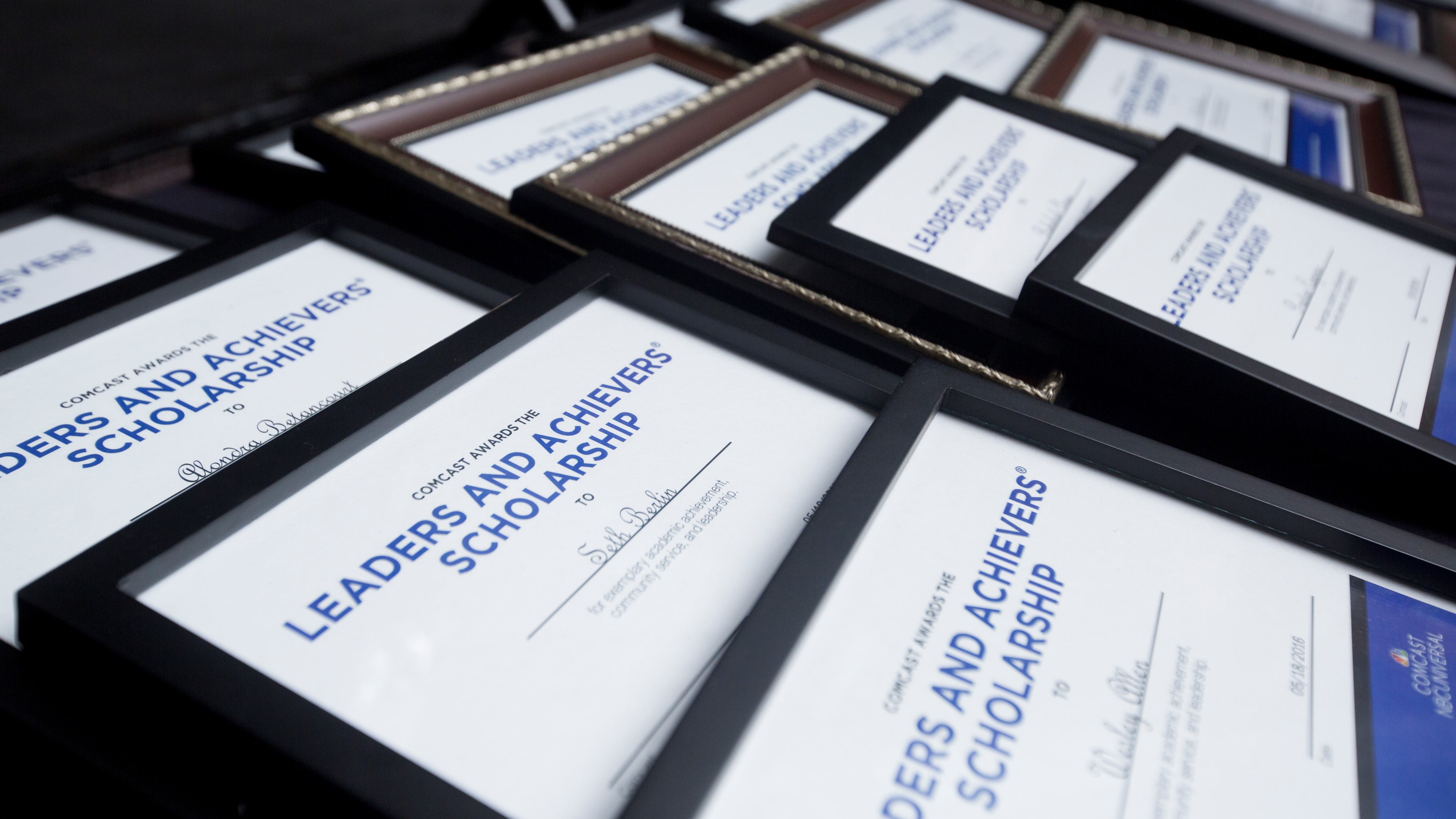 Rows of framed Leaders and Achievers Scholarship certificates.