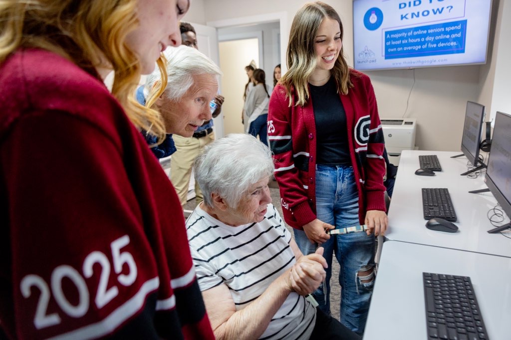 Students Tess Sellick, left, and Carly Andrews, right talk with Myron, top middle, and Sandra Ring in the new Comcast Digital Literacy Center at the Eagle Mountain Chamber of Commerce during a ribbon cutting event on Thurs., April 25, 2024 in Eagle Mountain, Utah.