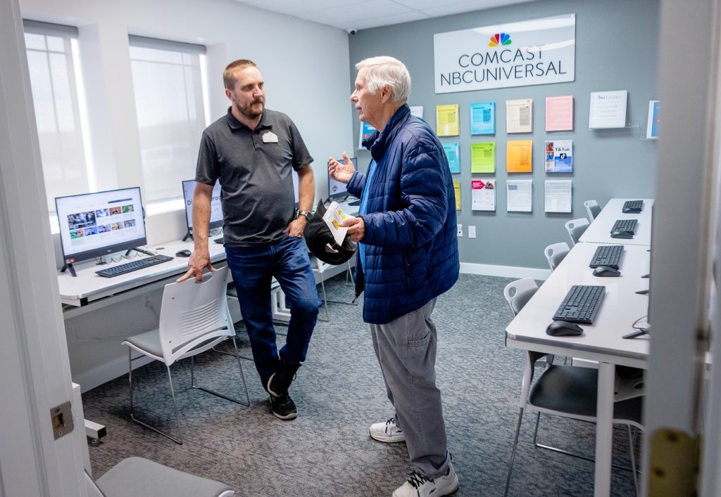 Kyle Weaver, left, from Comcast talks with Myron Ring, right, in the new Comcast Digital Literacy Center at the Eagle Mountain Chamber of Commerce during a ribbon cutting event on Thurs., April 25, 2024 in Eagle Mountain, Utah.