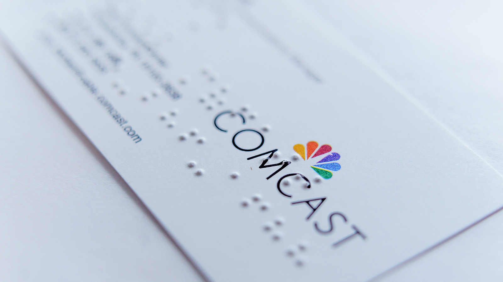 A Comcast business card covered in Braille.