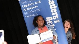 Leaders and Achievers winners pose in front of a poster