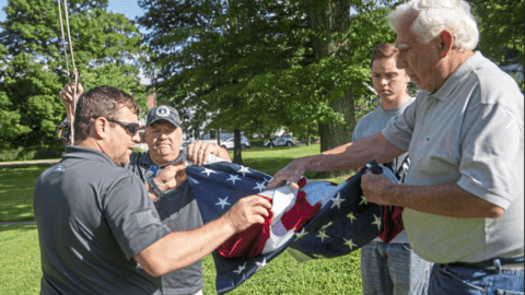 Comcast employees folding American flag