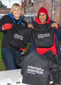 Two women holding Internet Essentials bags
