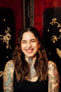 Woman with lots of tattoos smiling 