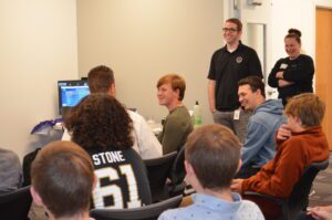 Students and adults laughing in a product lab