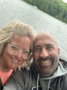 woman and man in front of a lake, smiling