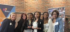 Group of two adult women with students holding trophy