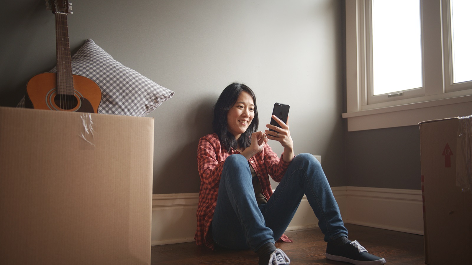 woman sitting on the floor of her apartment during a move