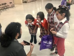 Comcast technician, Axel Hernandez, showing students his technology during the Discovery Festival. 